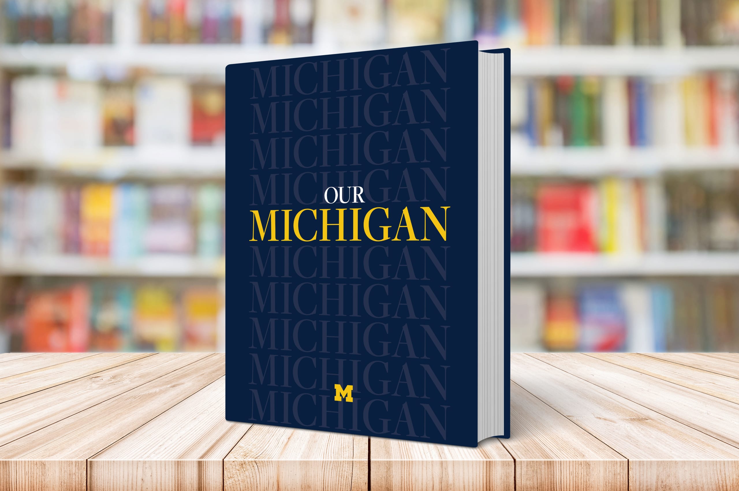 The Our Michigan book sits on a coffee table with a bookcase in the background