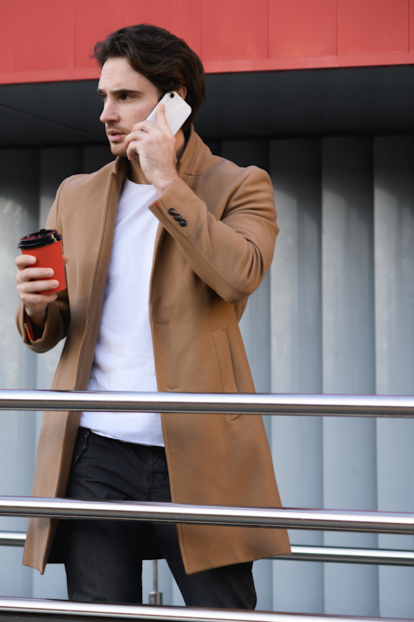 Busy working professional checking her phone with coffee in hand