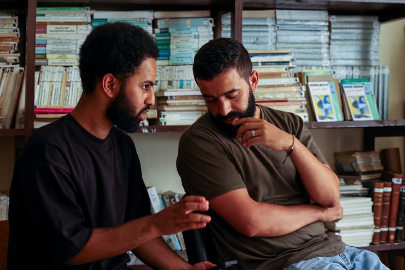 A documentary director moves to sit beside an interviewee in Morocco after the interview ends, continuing the conversation as the crew packs up, capturing the human connection at the heart of responsible documentary storytelling.