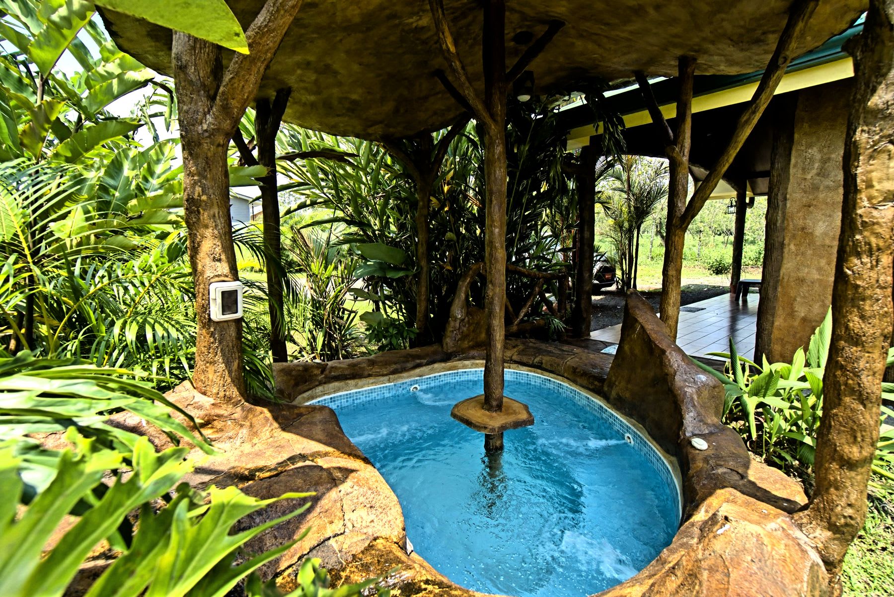 Covered jacuzzi surrounded by the garden.