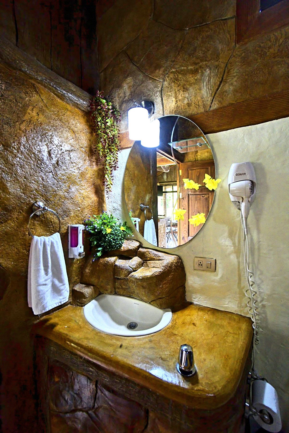 Stone sink, mirror and hair dryer.