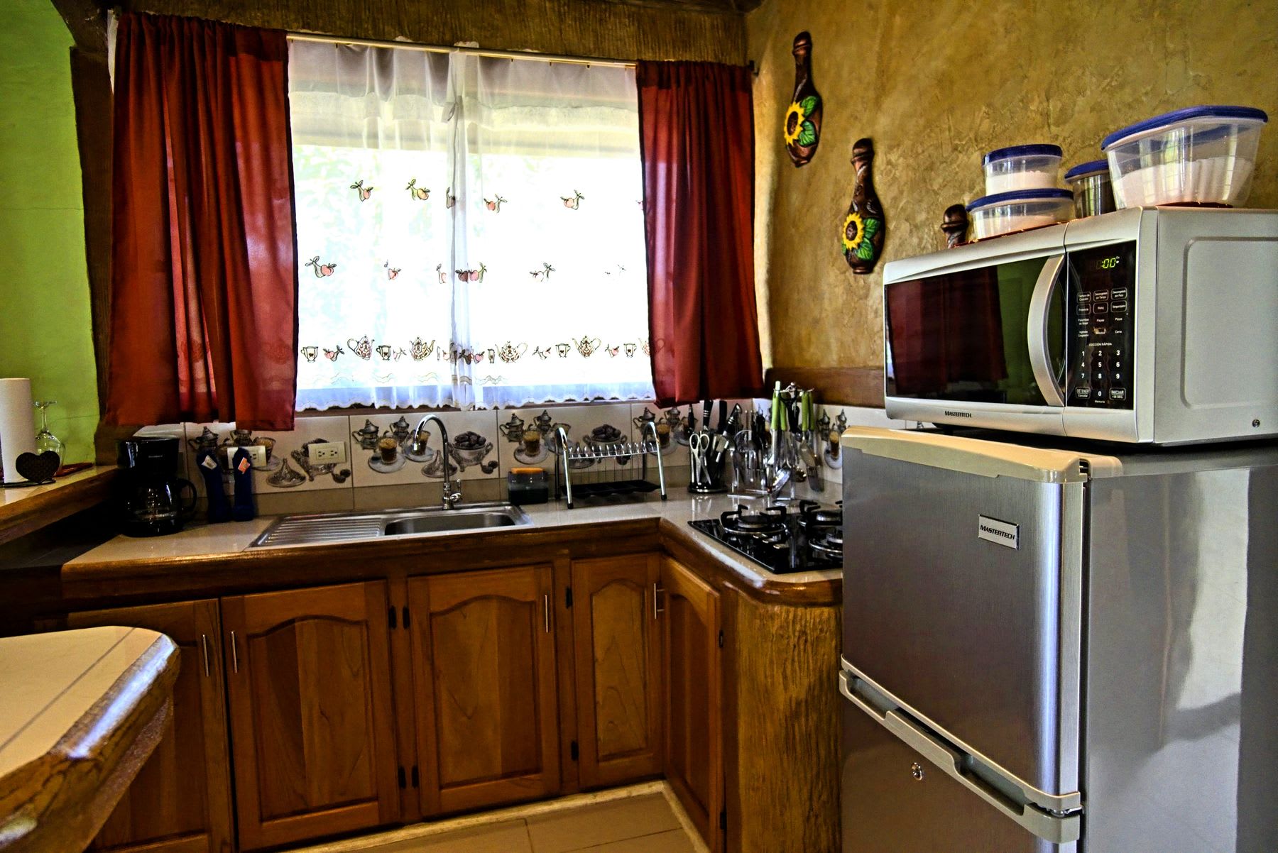 Equipped kitchen with stove, microwave, fridge and coffee maker.