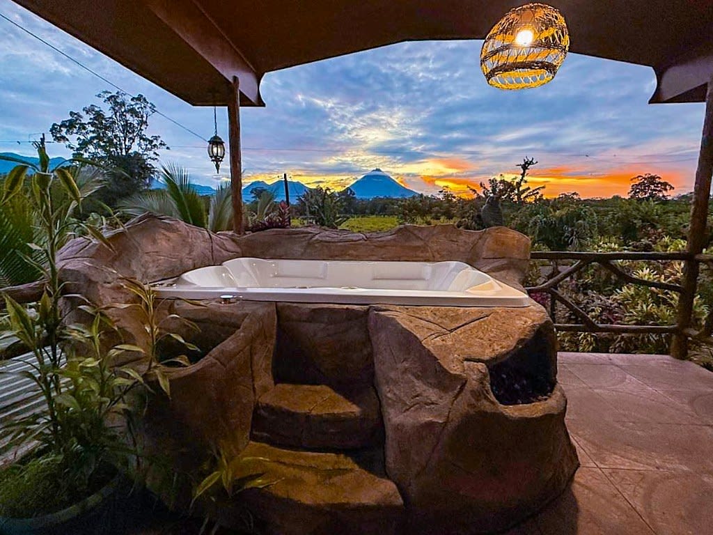 Villa Tucán's private jacuzzi at sunset, with Arenal Volcano behind it.
