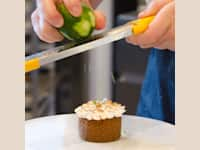 Pastry chef grating lime zest on a cupcake thumbnail