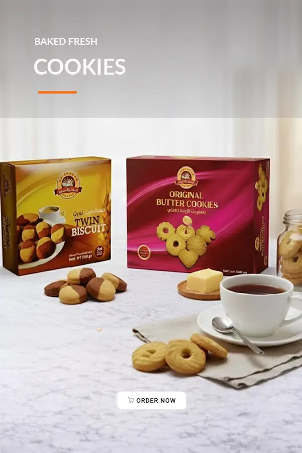 Image of freshly baked cookies, featuring Twin Biscuits and Original Butter Cookies packaging on a table, accompanied by a cup of tea and scattered cookies. Ideal for promoting baked goods.
