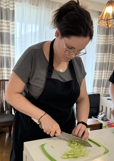 Milena is cutting vegetables on a cutting board