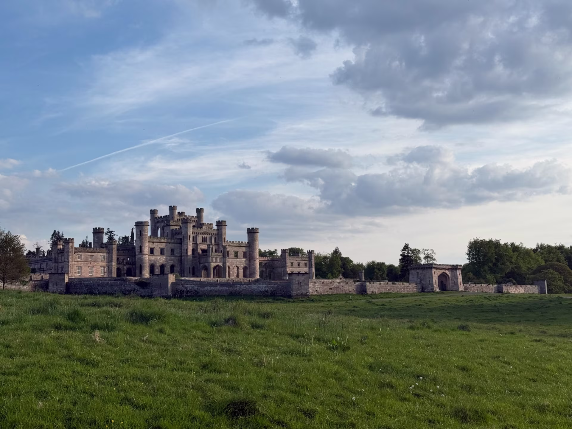 lowther castle viewed from grassy field under evening sky