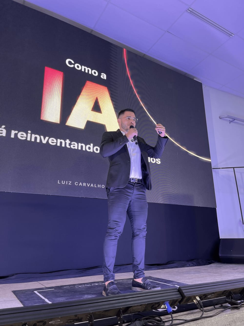 Luiz Carvalho diante do slide de abertura Como a IA está reinventando os negócios