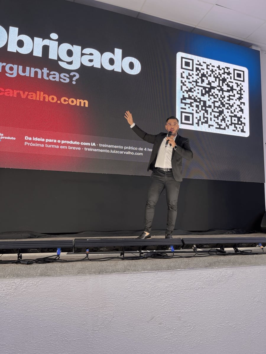 Luiz Carvalho no encerramento, diante do slide Obrigado, Perguntas? com um QR code