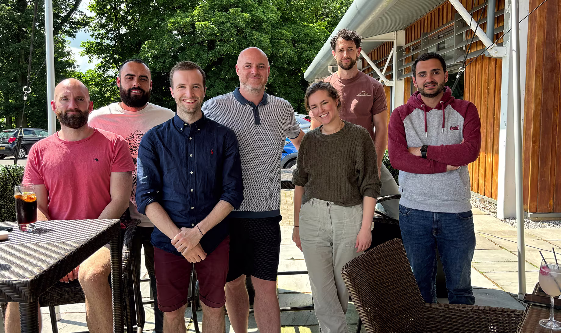 Group of True9 colleagues posing outdoors in casual wear