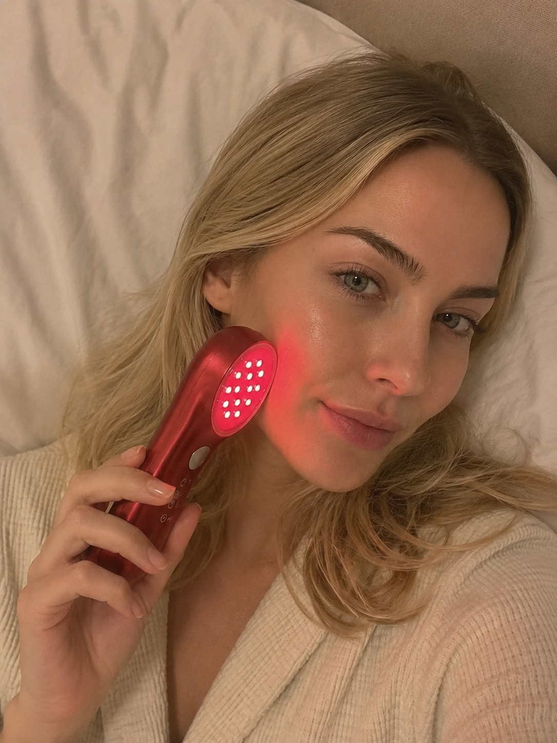 Woman using red light therapy device for acne scars skincare routine