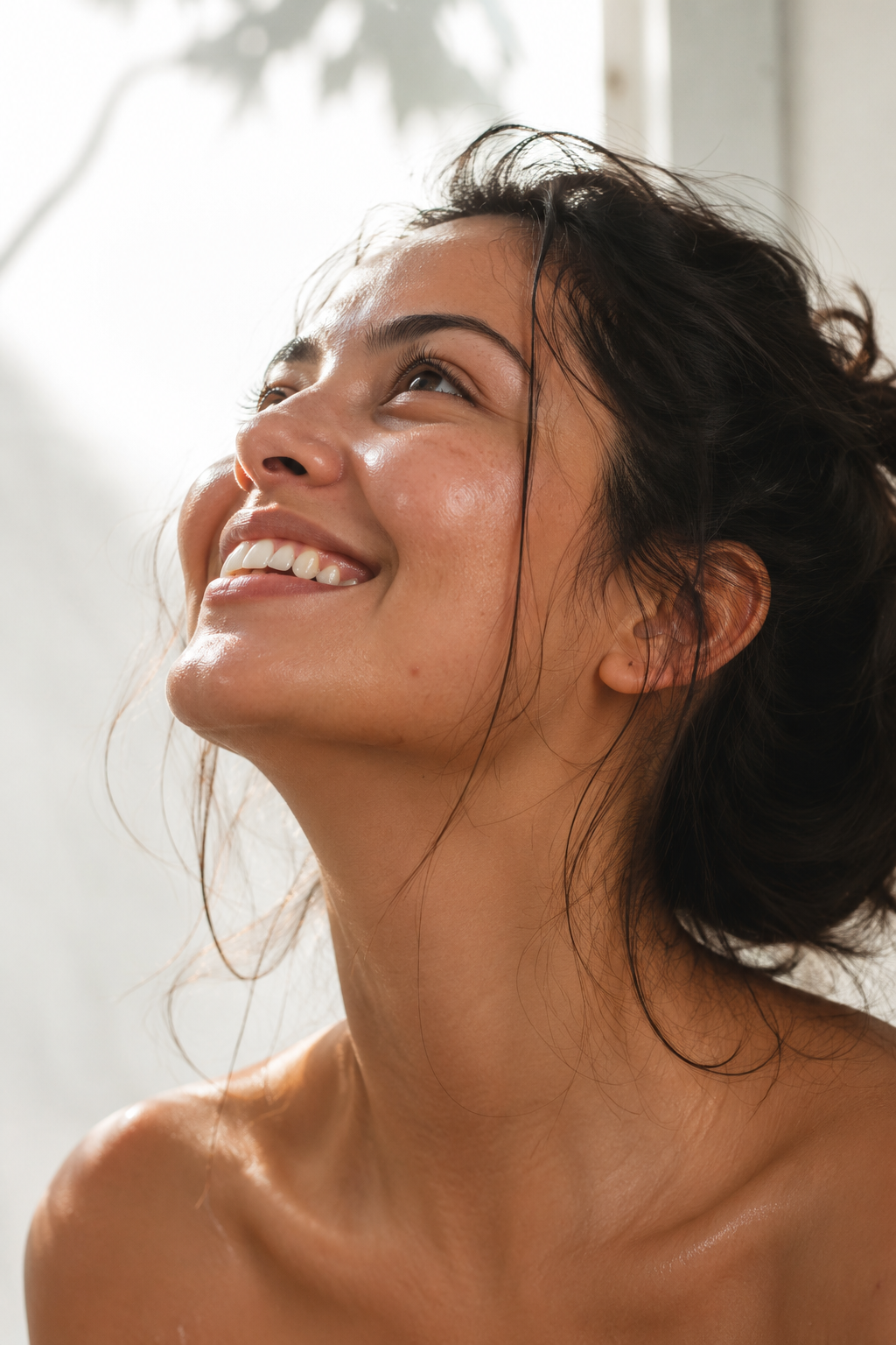 Woman with healthy glowing skin holding a minimal skincare bottle representing skin longevity philosophy
