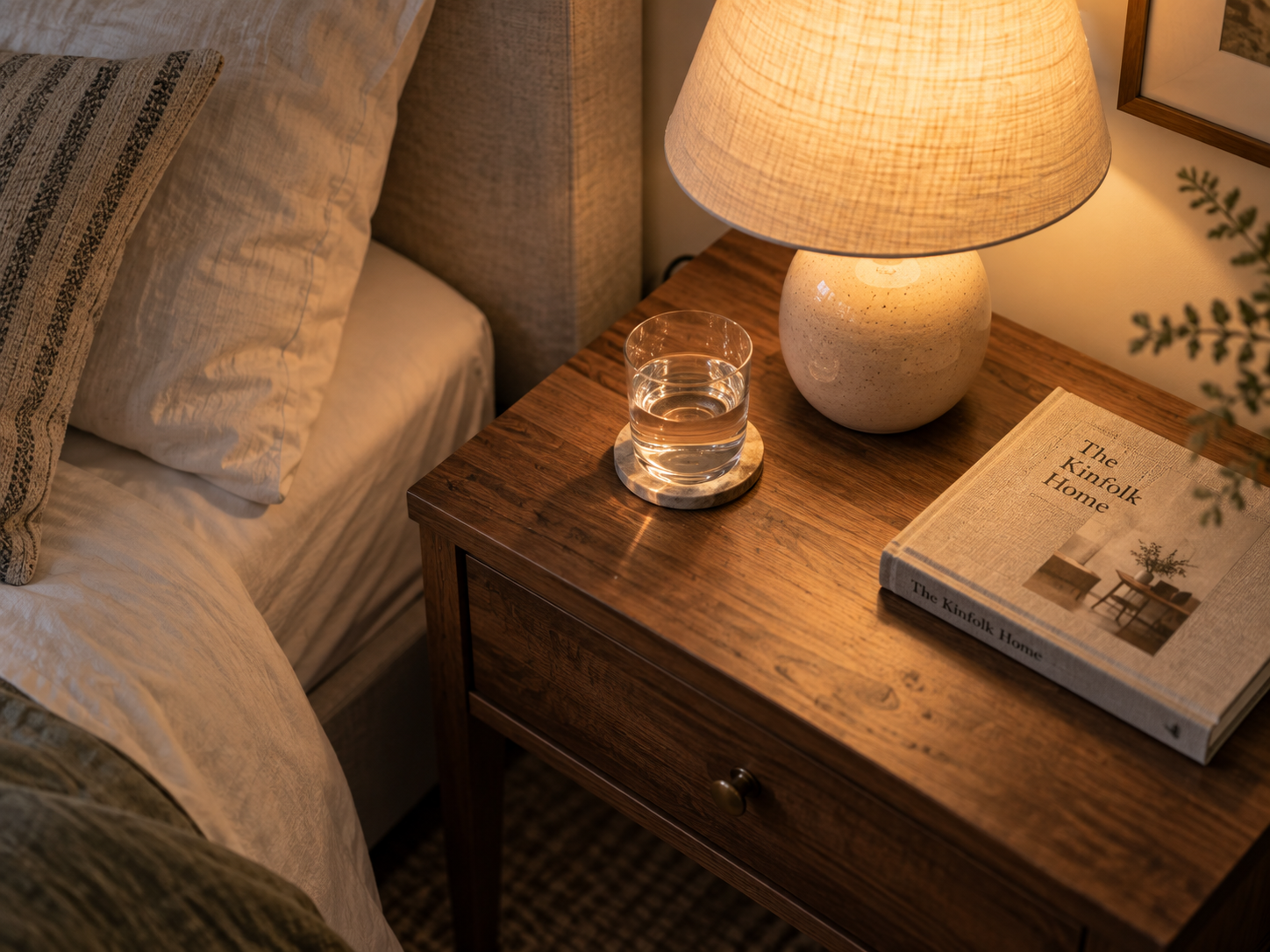 Calm bedside table with minimal objects and warm lamp light