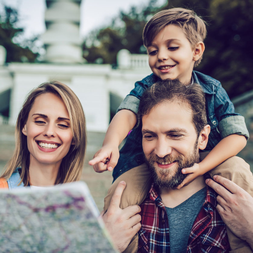 A man, a woman and a boy watching a map