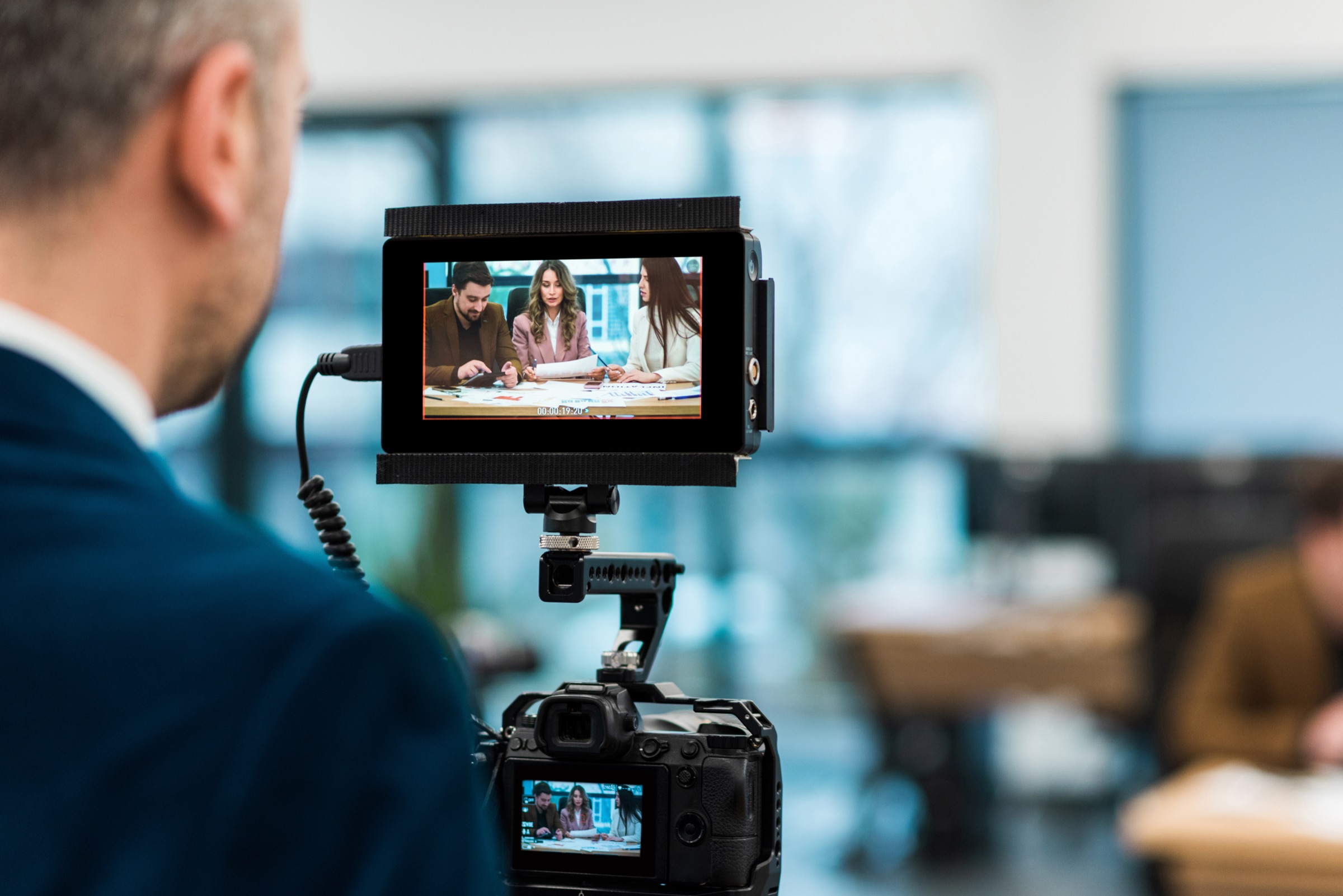 Professional videographer filming a business meeting for VR JobMatch's corporate culture video.