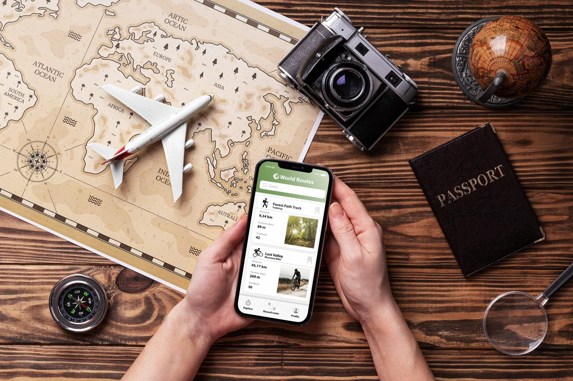 A traveller's desk with a map, passport, compass and phone