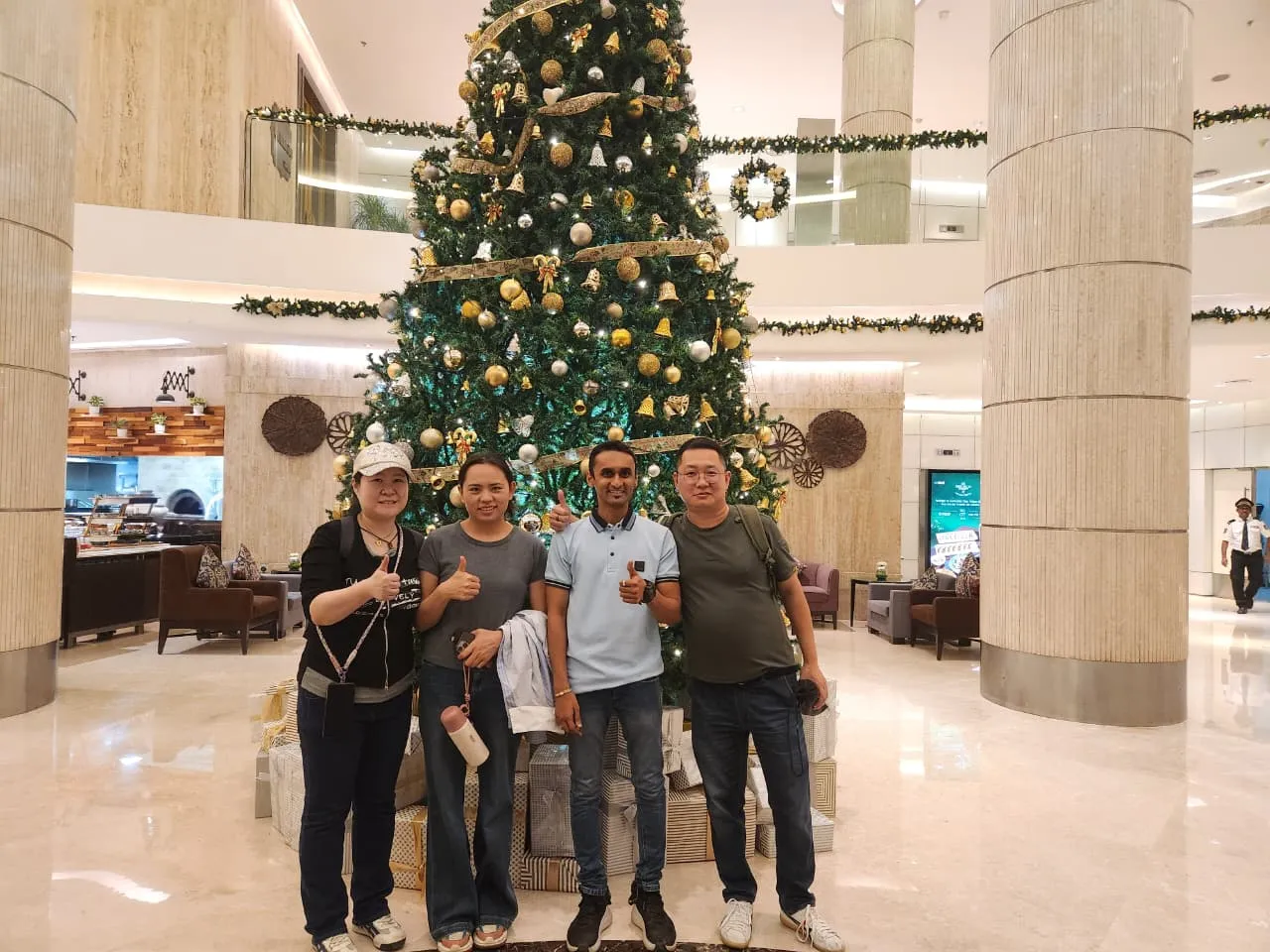 酷熊猫旅客们在酒店大堂的圣诞树旁合影