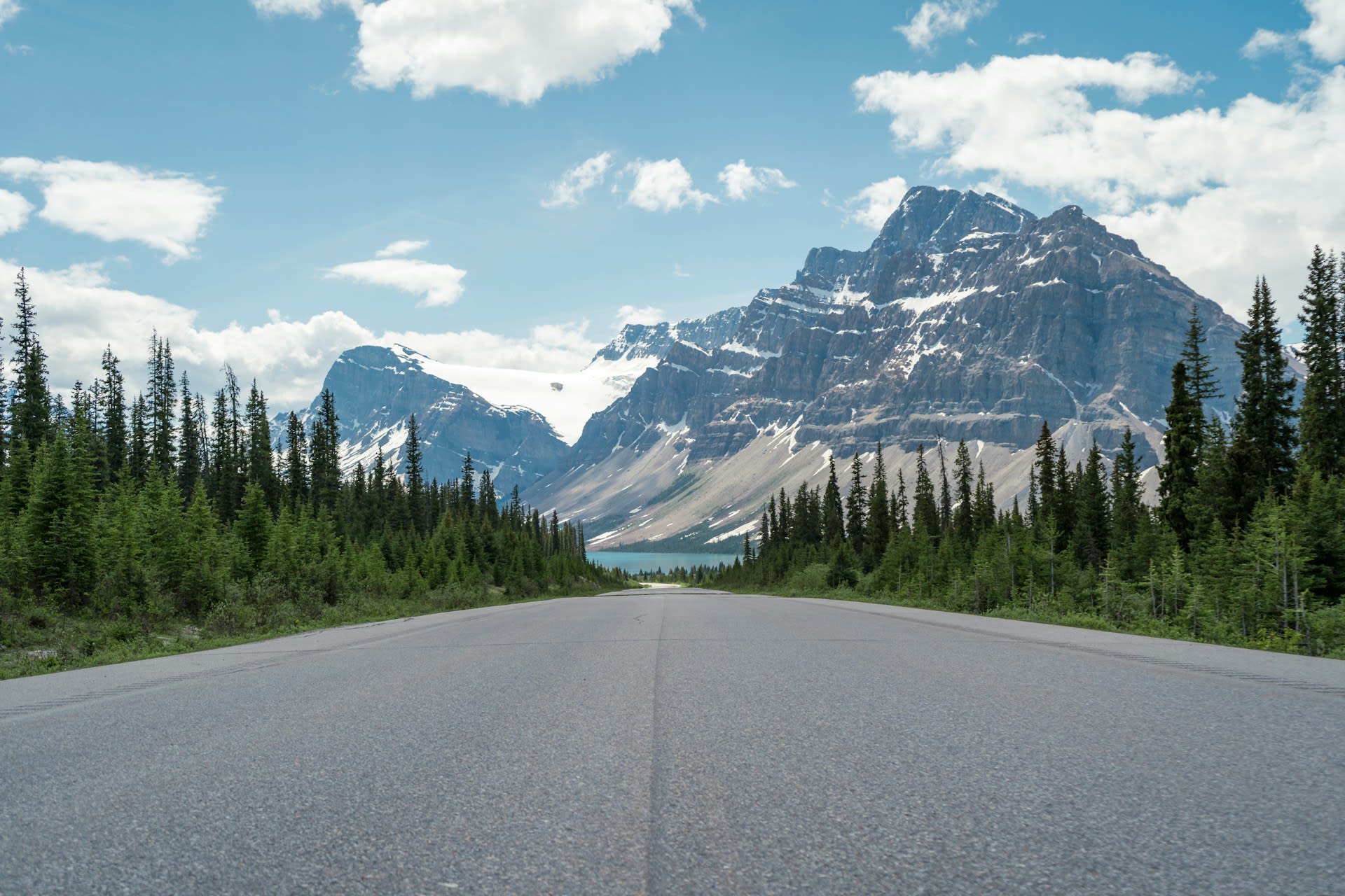 Aerial view of the Icefields Parkway winding through the Canadian Rockies with snow-capped peaks and glaciers