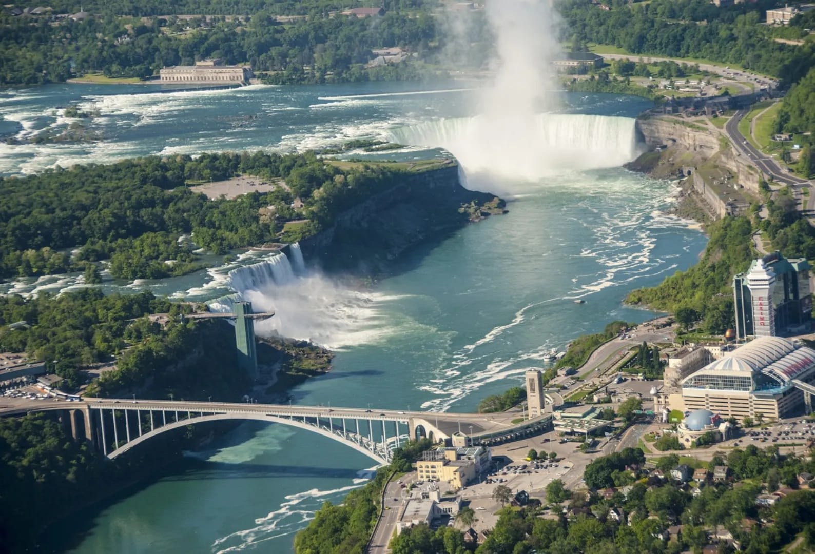 View of Niagara Falls area featuring buildings and a bridge over the river, capturing the natural and urban landscape.
