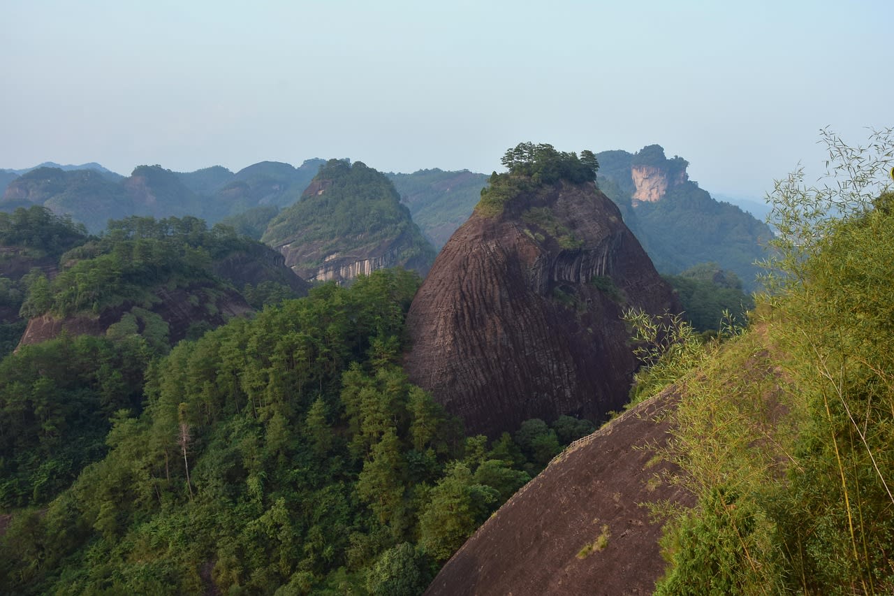 Red sandstone peaks of Mount Wuyi rising from the misty Nine Bend River gorge in Fujian Province China