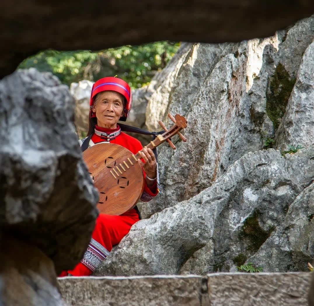 Woman with a string instrument among rocks, Shilin