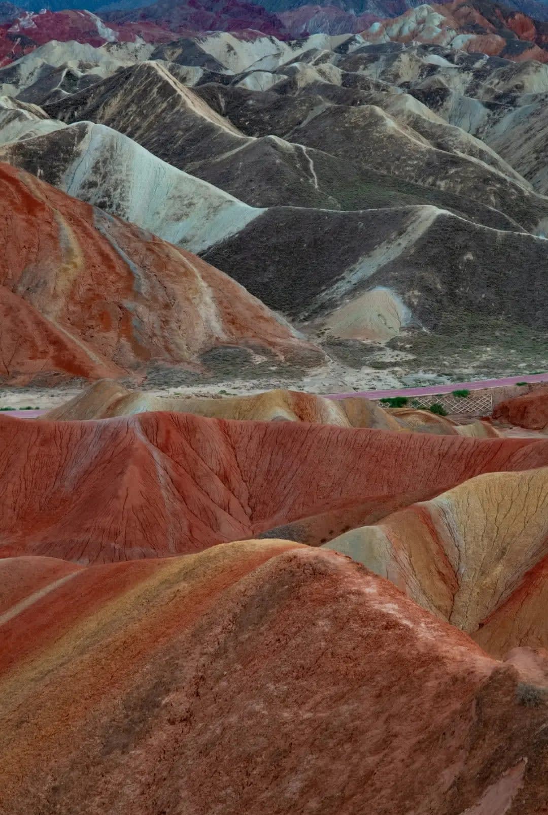 Mountains with a multicolored surface, including yellow, brown, red, and green, Zhangya-Danxia-Dimao
