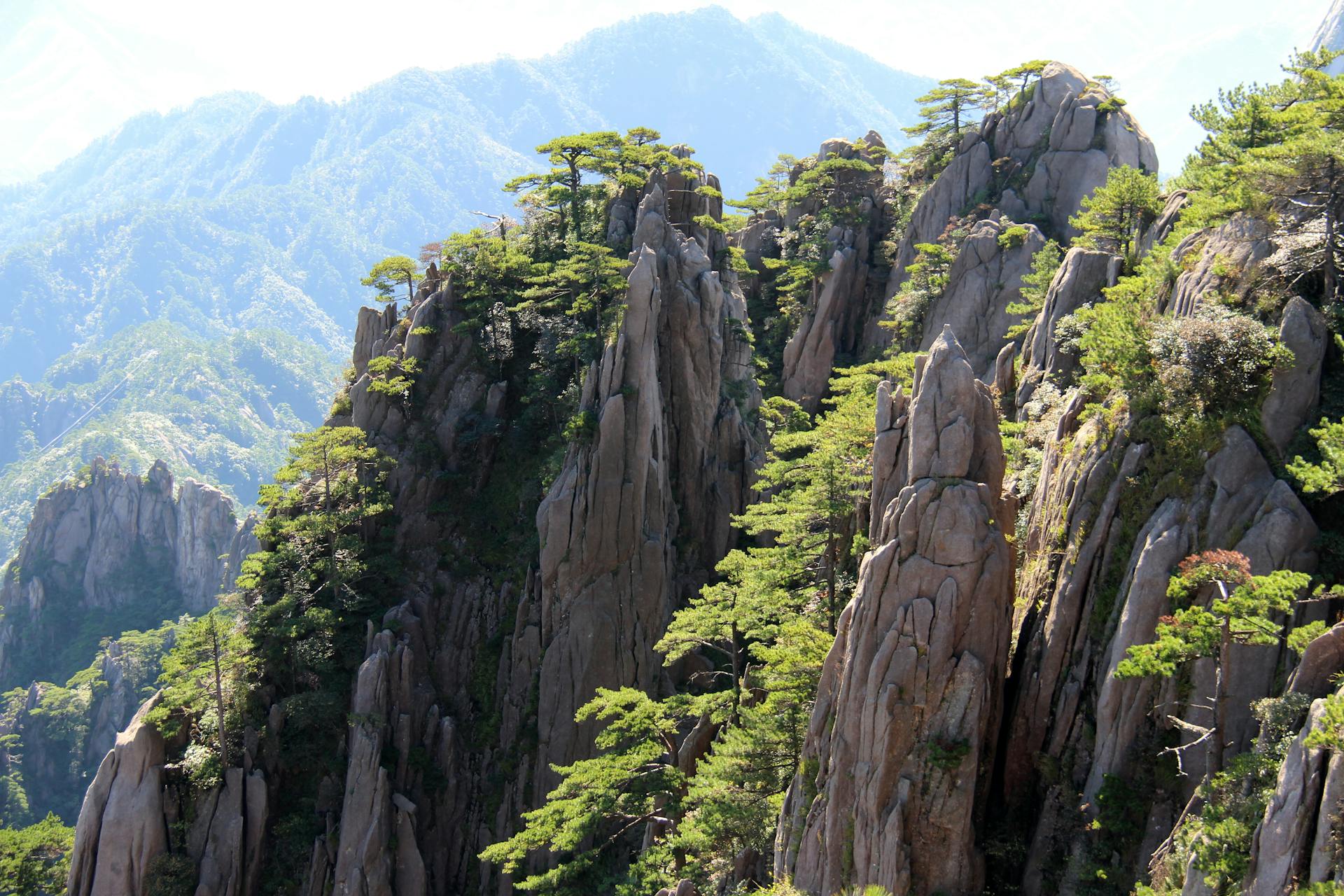 rock formations like towers between mountains with vegetation, Huangshan