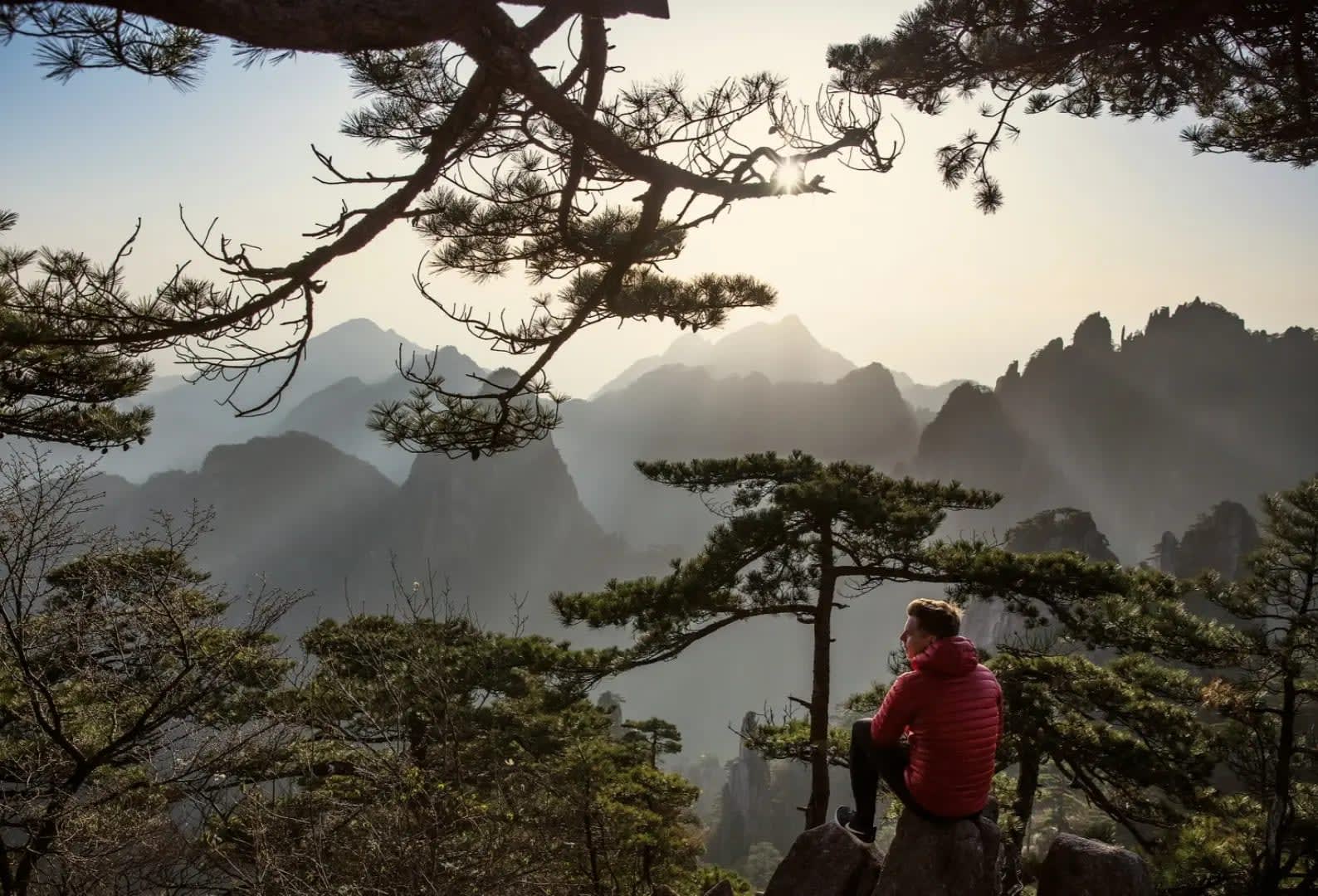 sunset in the mountains with a man admiring the landscape, Huangshan