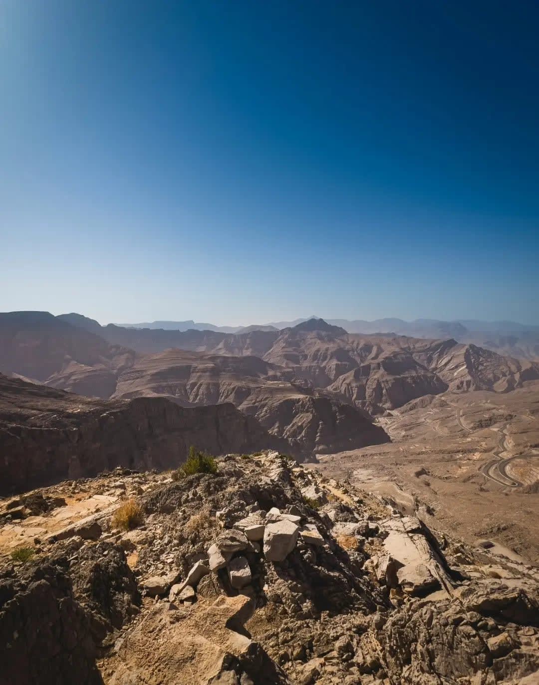 Aerial view of rocky, dry mountains with a road, Jebel Jais