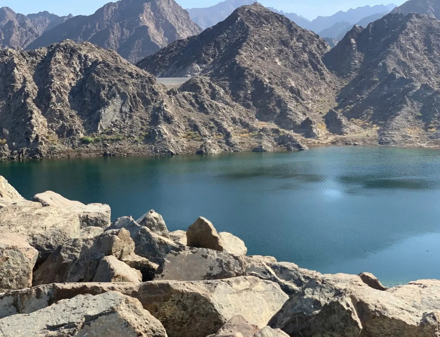 Lake in front of rocky, dry mountains, Jibal Hatta