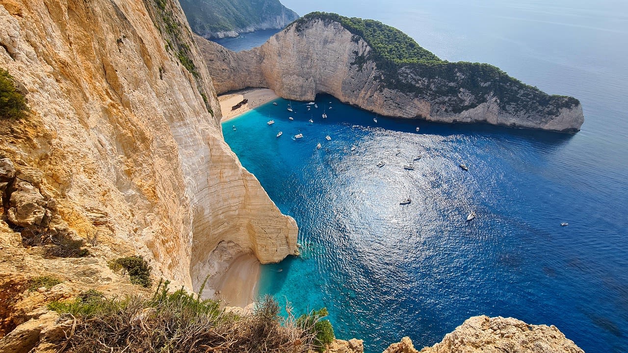 The MV Panagiotis shipwreck rusting on the white pebble shore of Navagio Beach Zakynthos with turquoise water