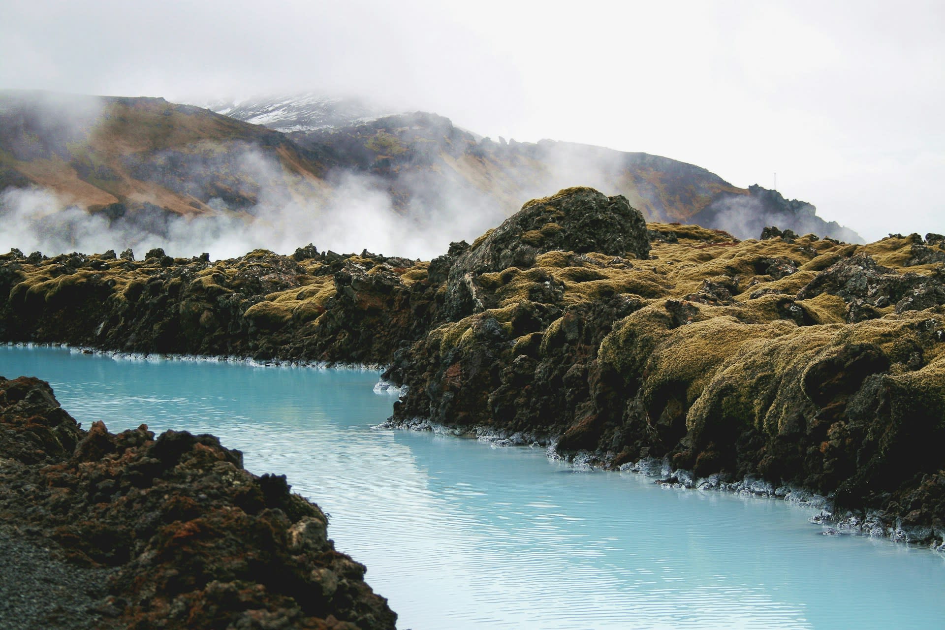 Steam rising from the Blue Lagoon surface against a dramatic Icelandic winter sky