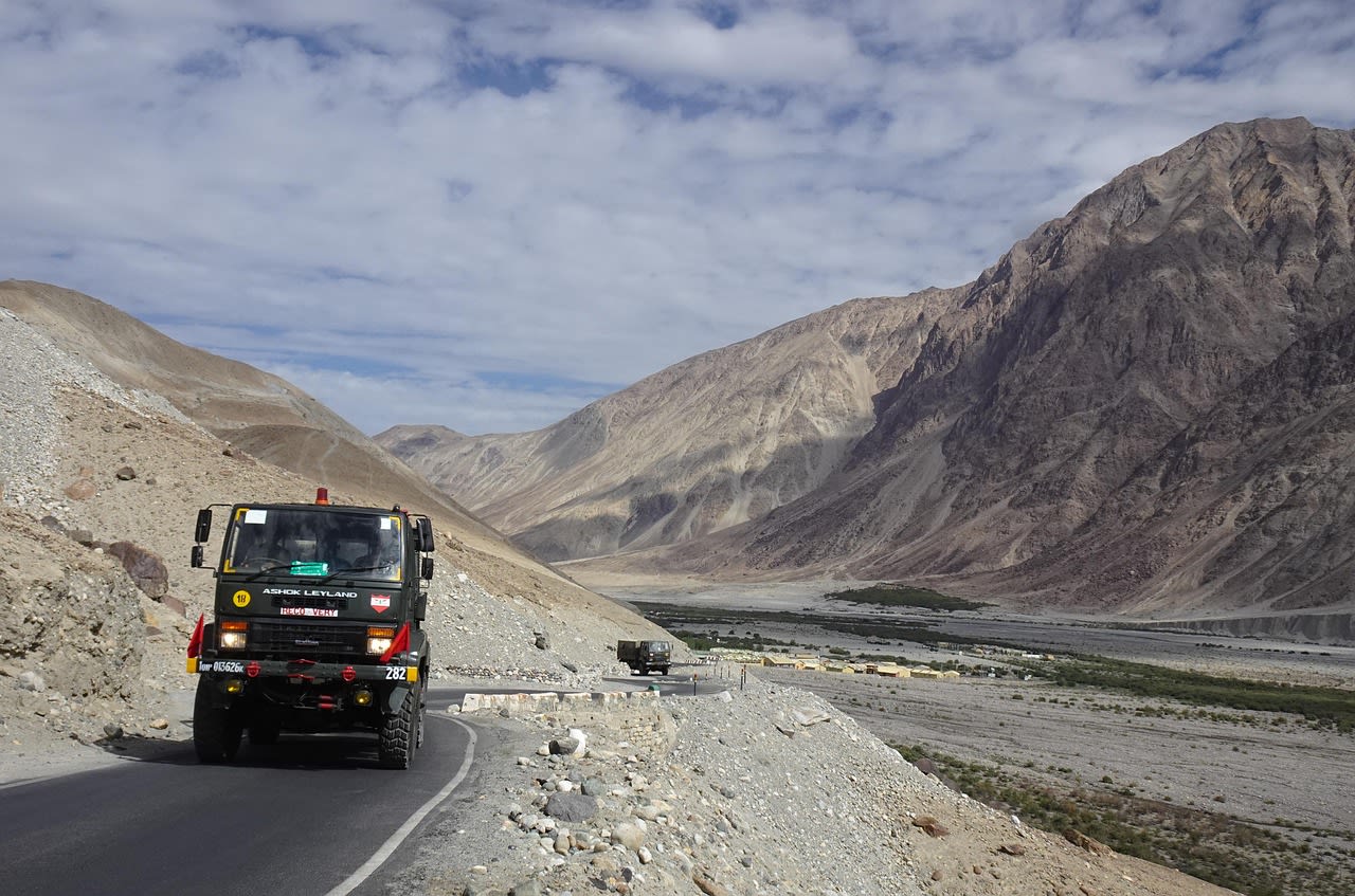 Ancient Thiksey monastery perched on a hill above the Indus Valley in Ladakh with snow peaks behind
