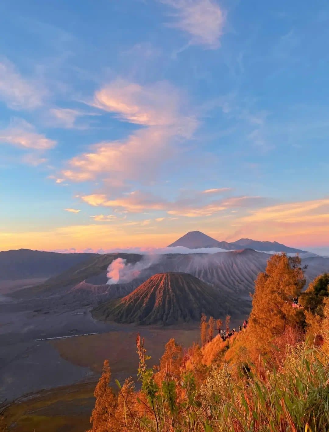 Wrinkled mountains with smoke rising from one, Gunung Bromo