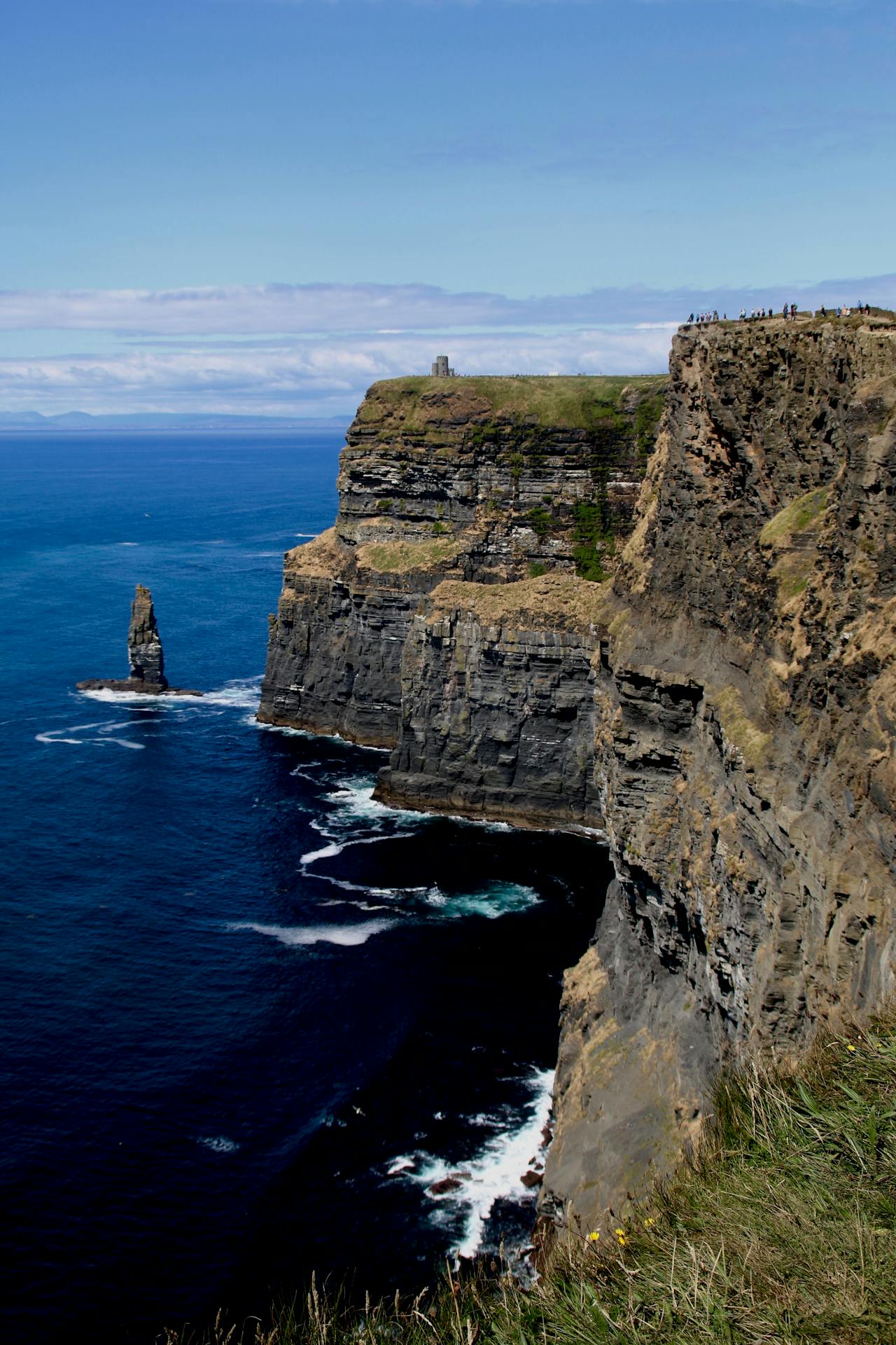 Sunset light over the Cliffs of Moher casting golden reflections on the Atlantic waves below