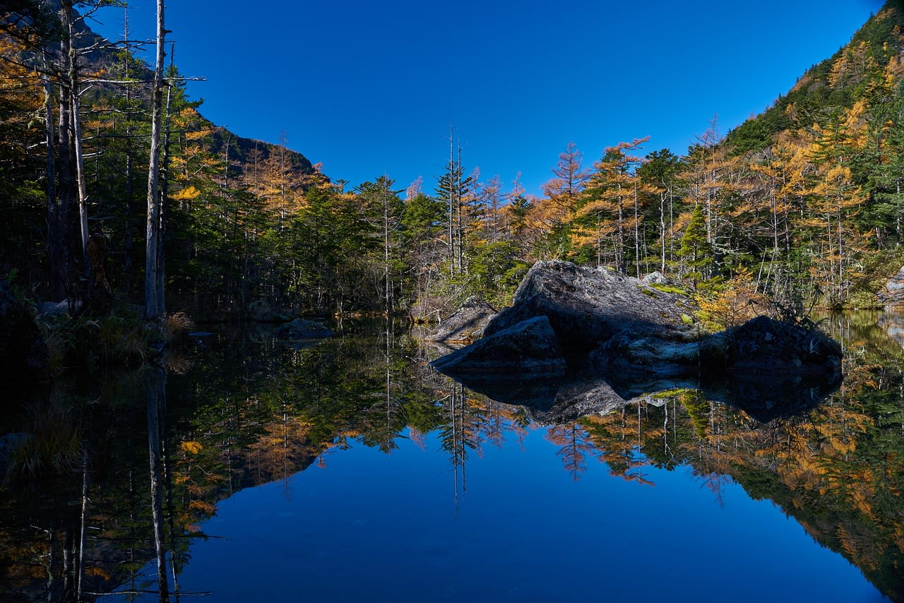 Taisho Pond reflecting the snowy Hotaka peaks in Kamikochi alpine valley Japan