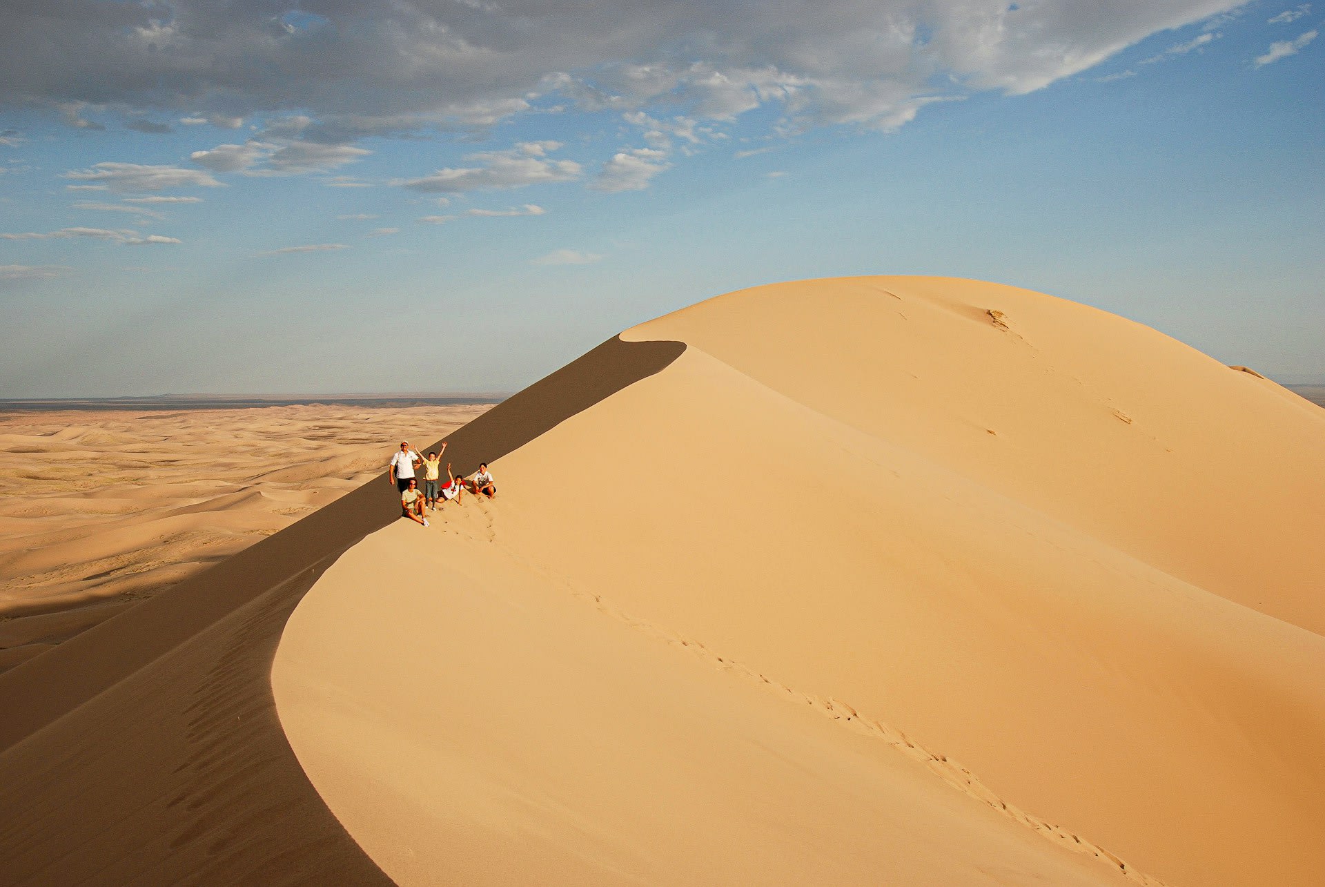 Nomadic Mongolian family ger camp at dawn in the Gobi Desert with the sandy landscape stretching to the horizon