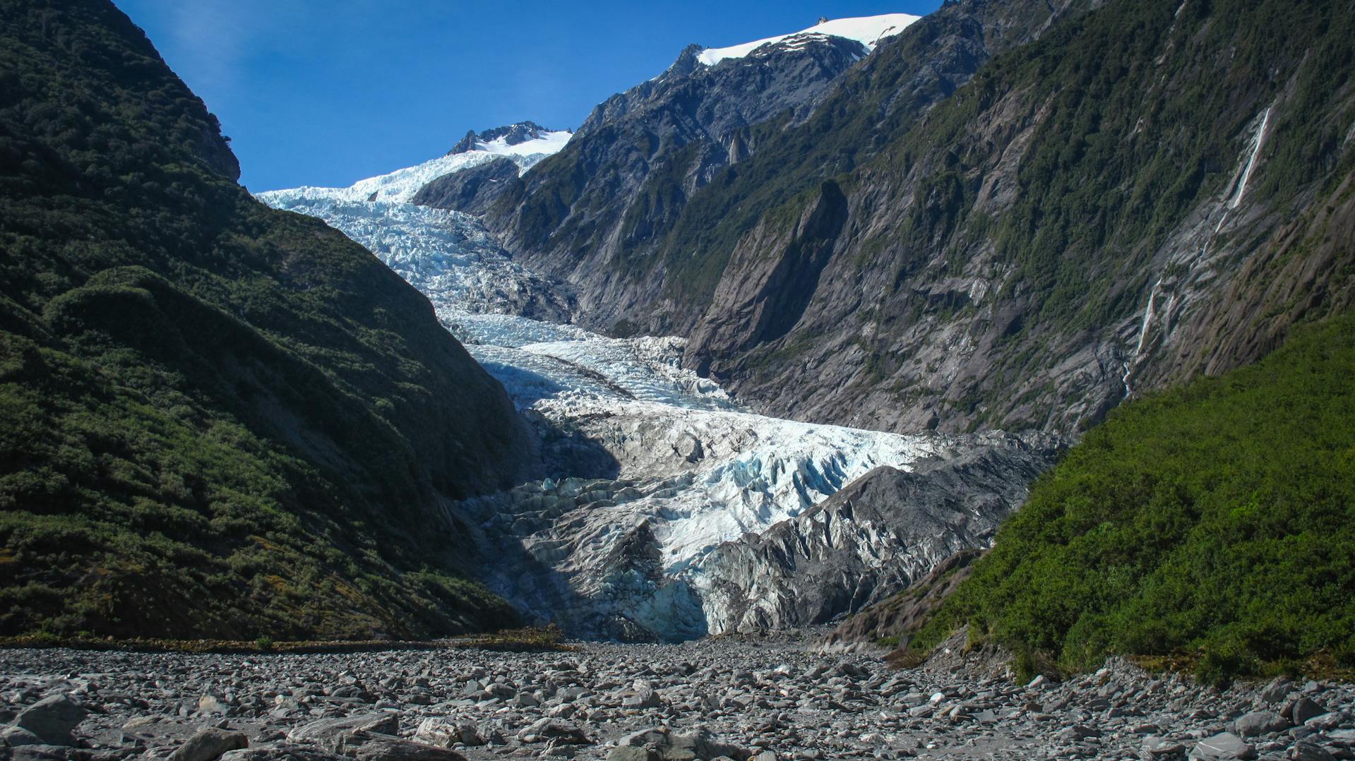 Franz Josef Glacier ice face flowing through the rainforest valley in Westland National Park New Zealand