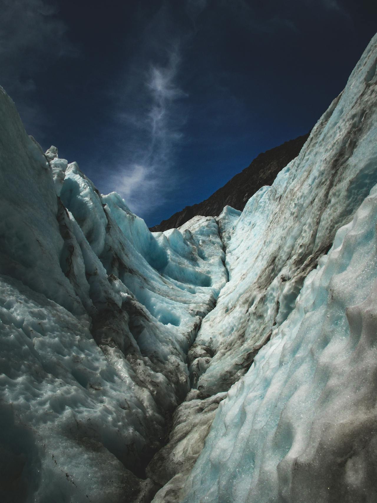 Guide leading hikers through an ice cave on Franz Josef Glacier in Westland New Zealand