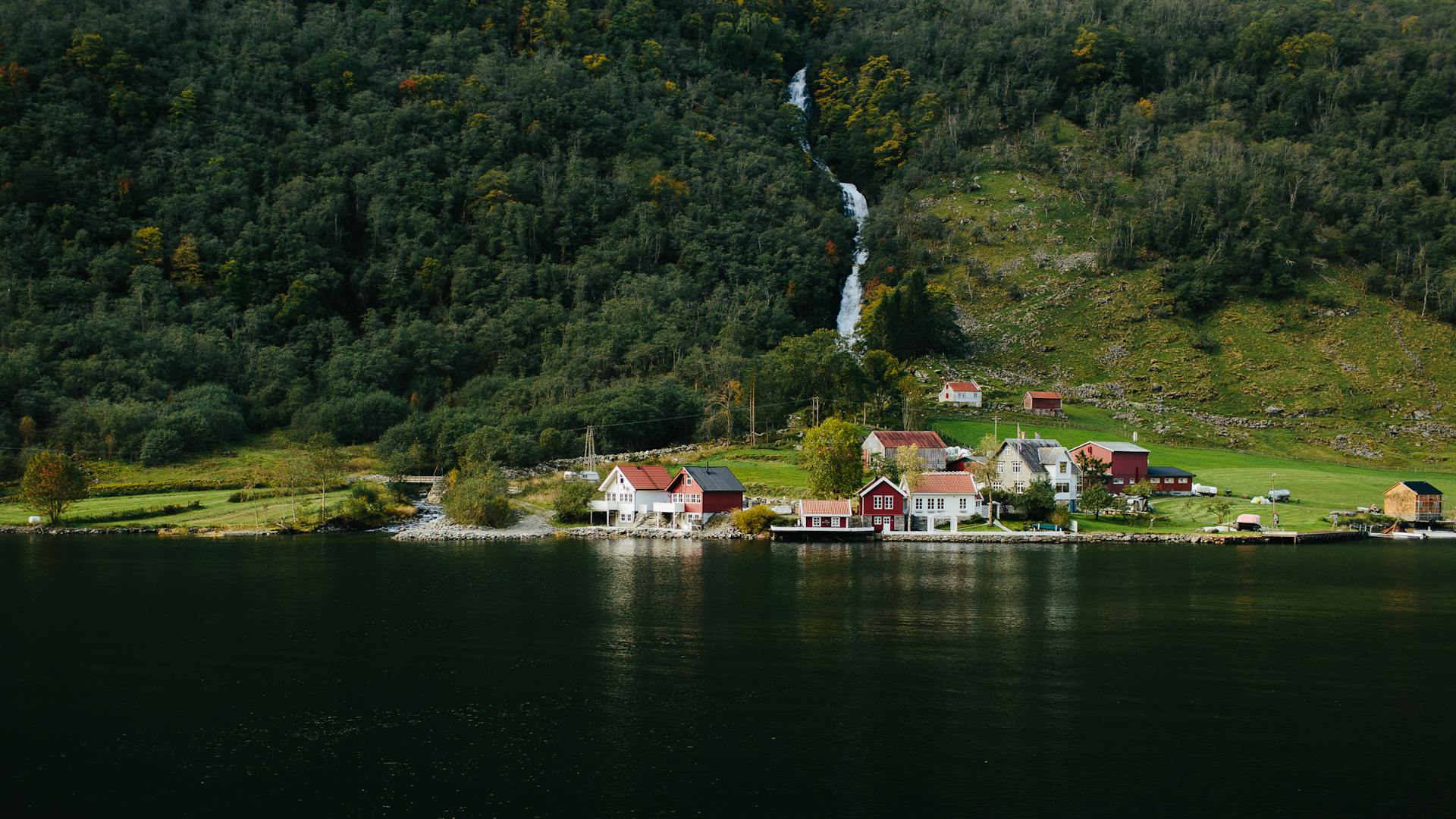 Small traditional wooden boat navigating the world's narrowest navigable fjord in western Norway