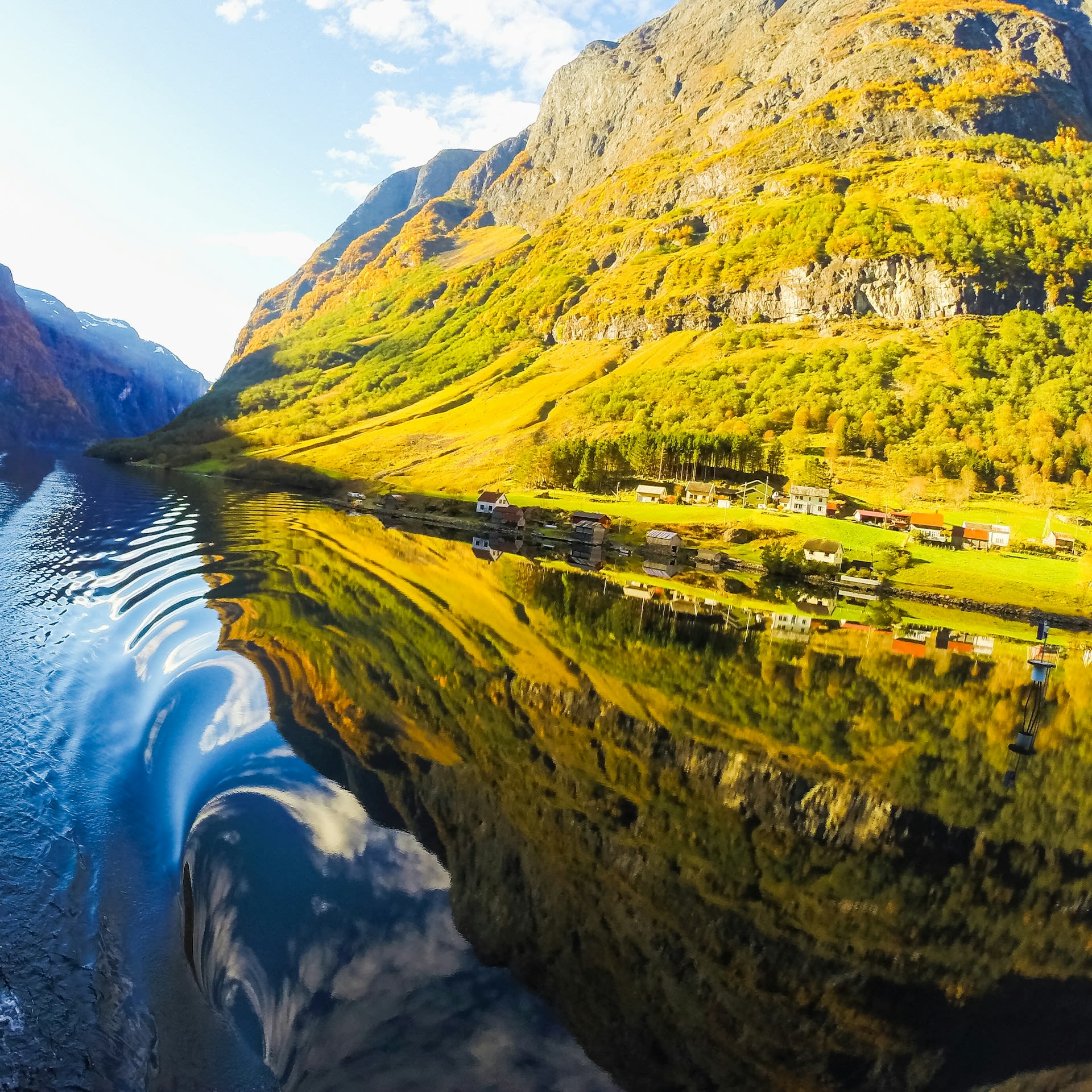Snow-capped mountain ridgeline rising above the narrow waterway of Nærøyfjord in Sogn og Fjordane