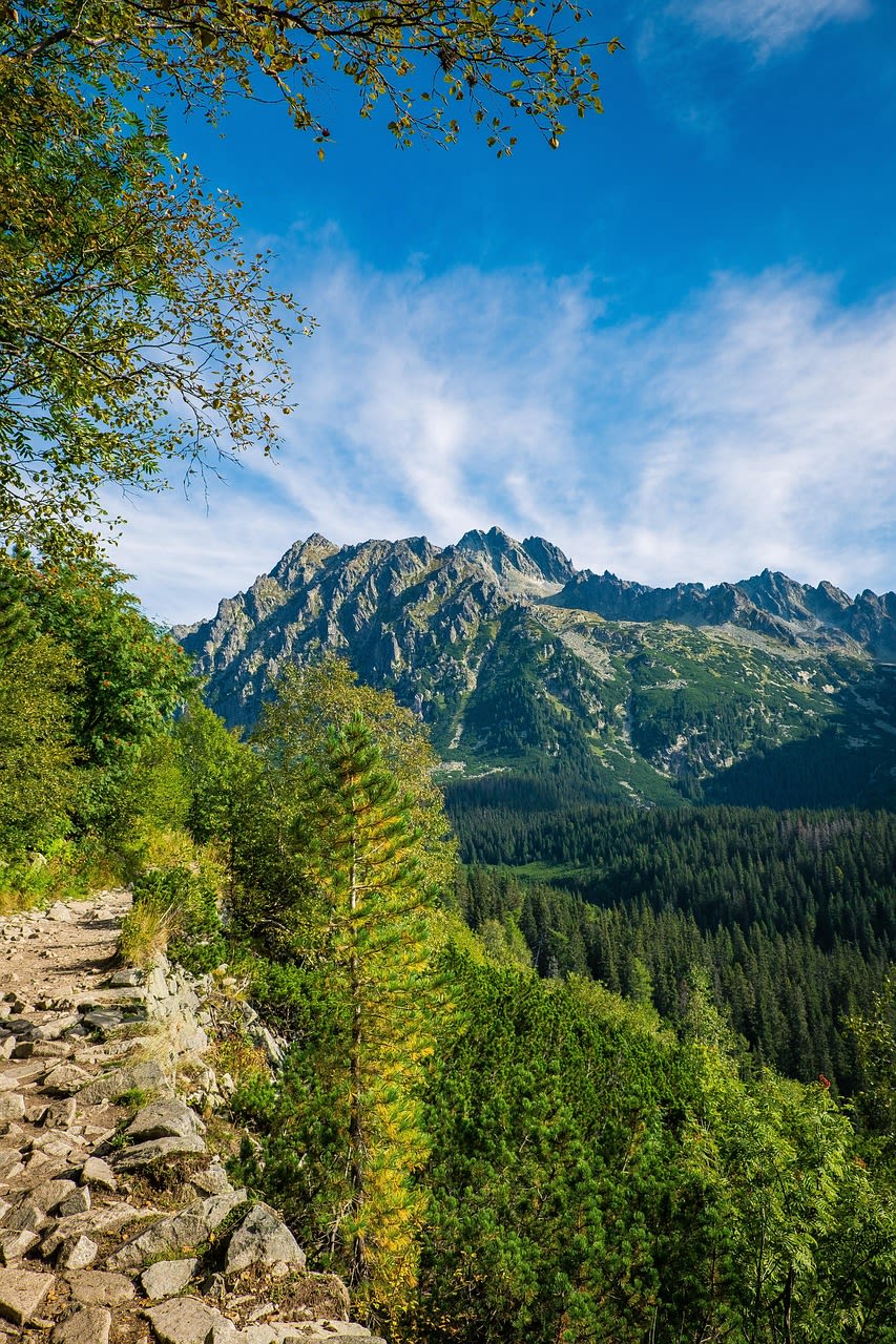 Hikers on the rocky Orla Perc trail in the High Tatras with vertiginous mountain views
