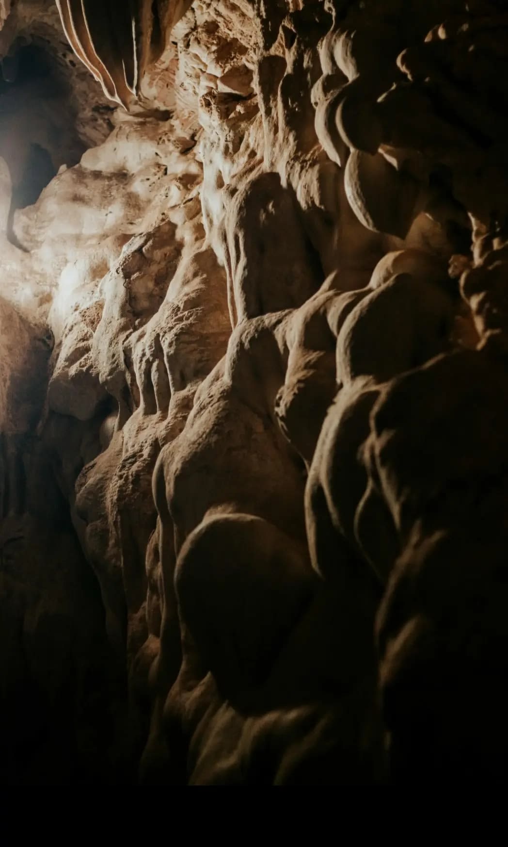 Close-up view of a rough, textured wall inside Cueva Ventana, showcasing the natural rock formations and intricate patterns created by erosion over time.