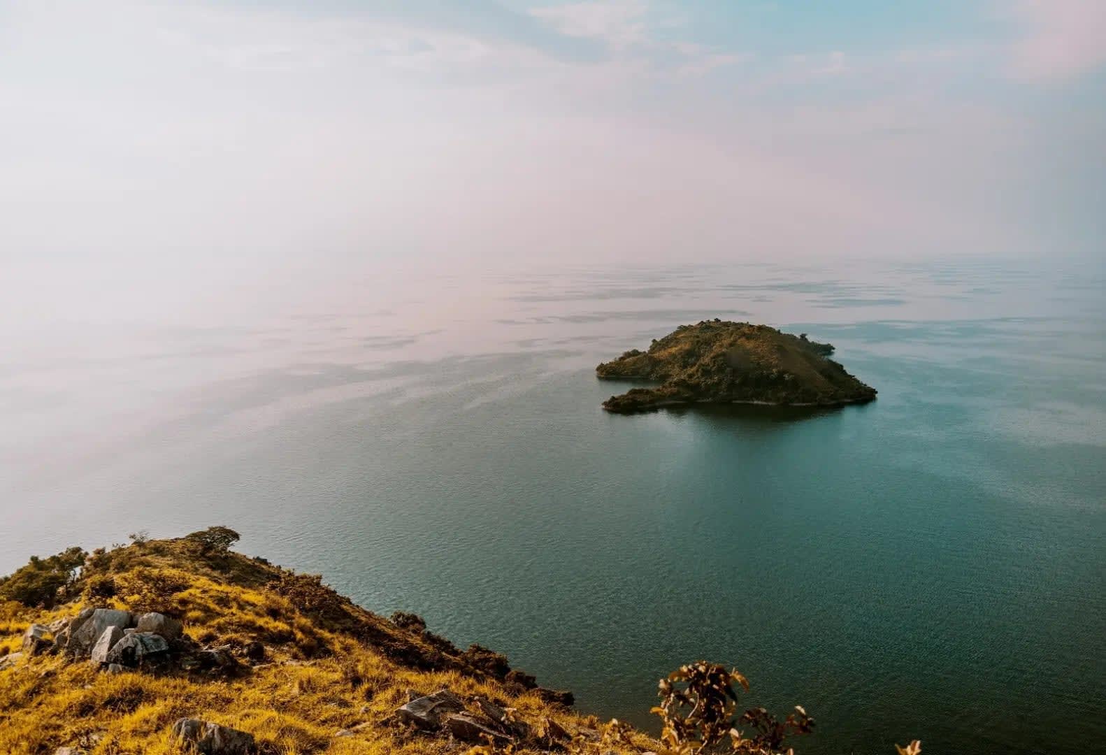 Lonely island in the middle of a large lake with mountains in the background,Lake Kivu