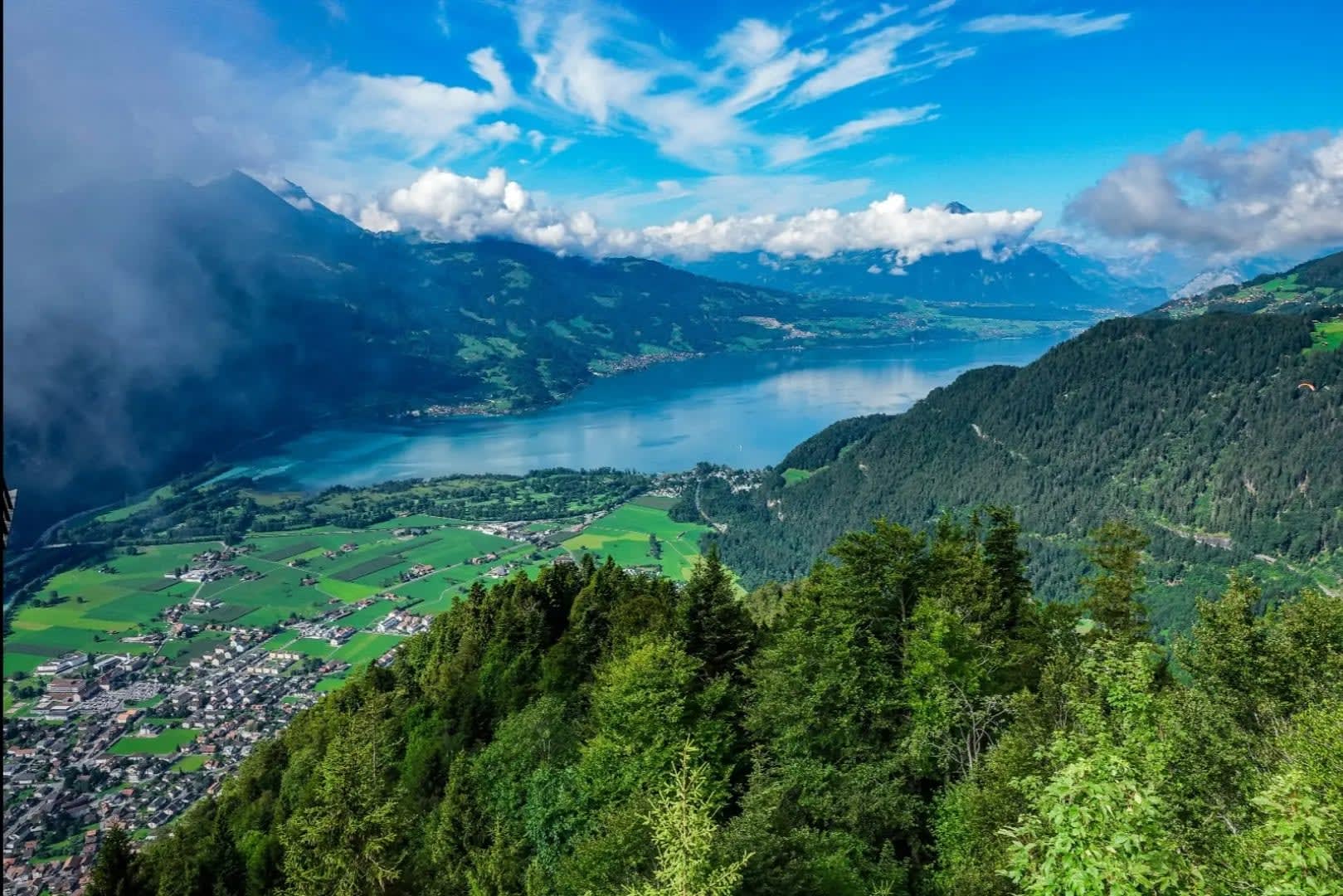 aerial view of a village nestled between mountain ranges and facing a lake, Interlaken