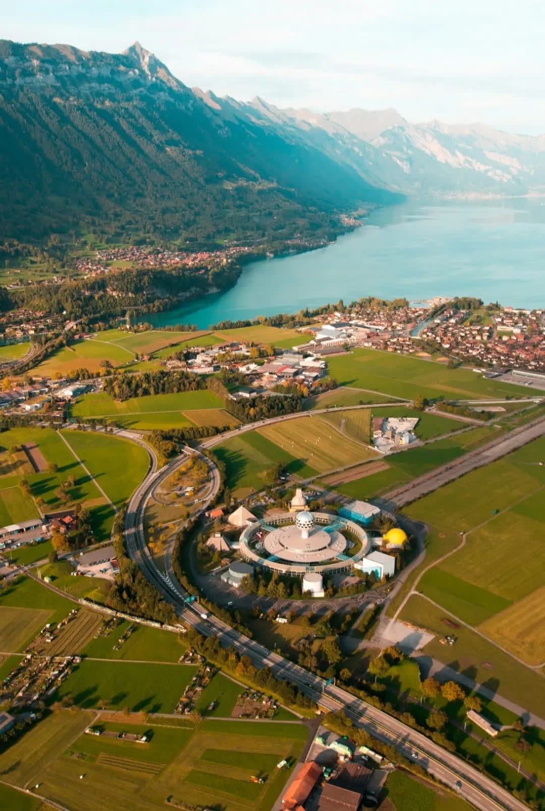 aerial view of a village nestled between mountain ranges and facing a lake, Interlaken