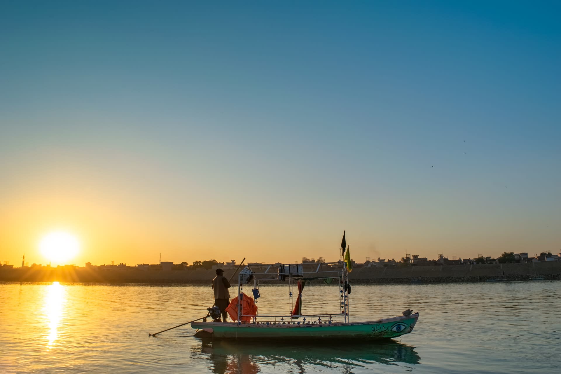 Boats on the water at a busy Karachi beach with the Arabian Sea horizon, Pakistan
