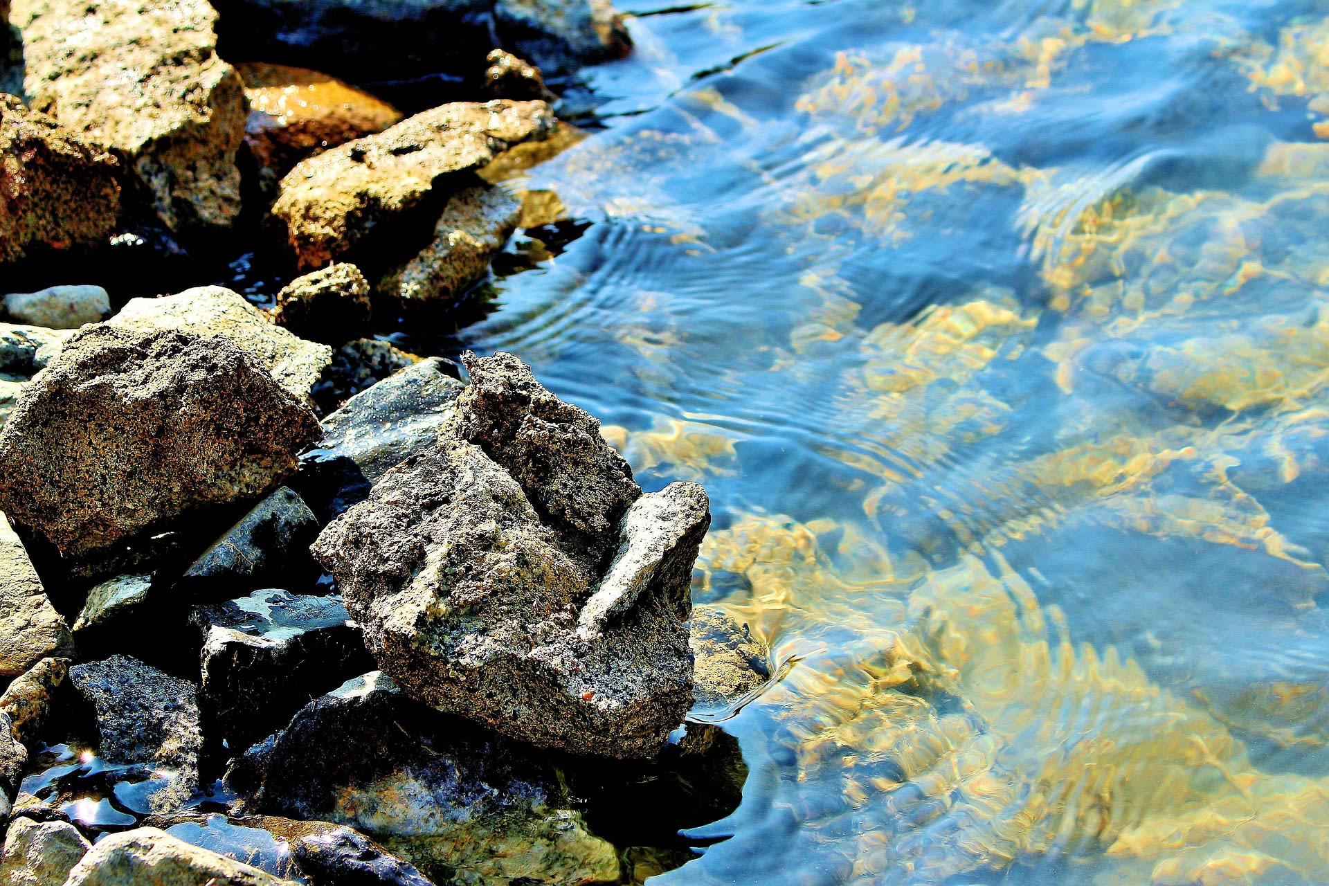Calm surface of Lake Satpara with rocky shores and mountain backdrop, Pakistan