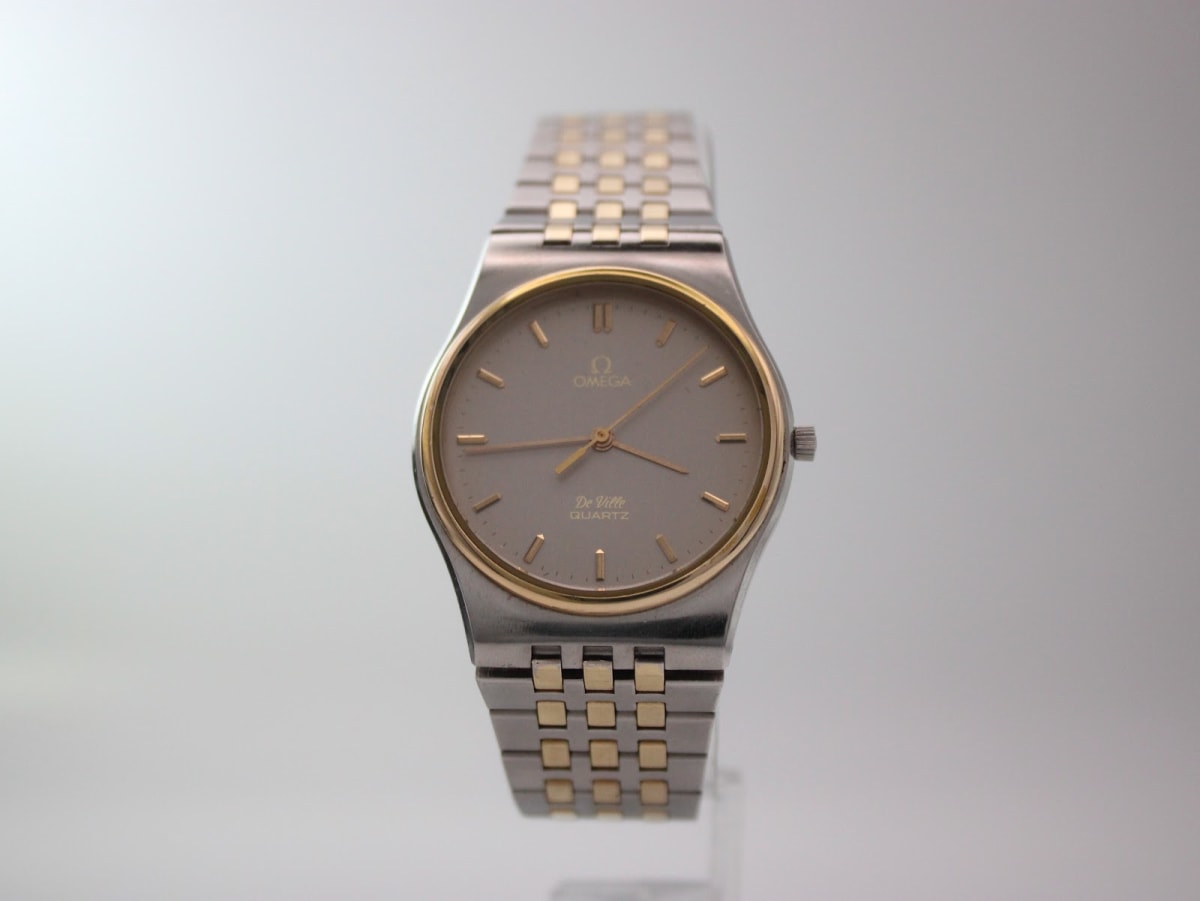 Front view of the two-tone Omega De Ville quartz watch with a grey dial and gold accents.