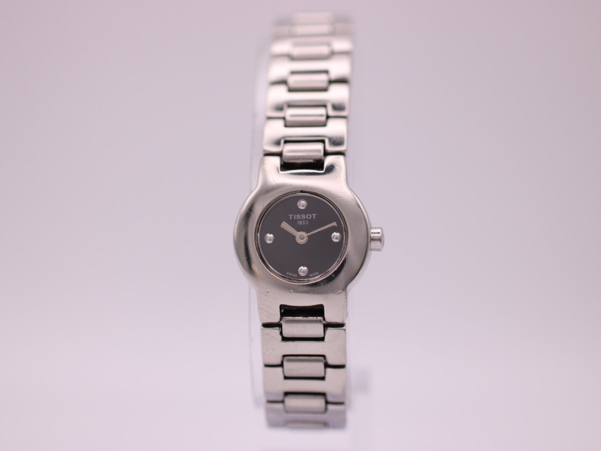 Front view of the Tissot G331K ladies' watch with black dial and integrated silver-tone bracelet.